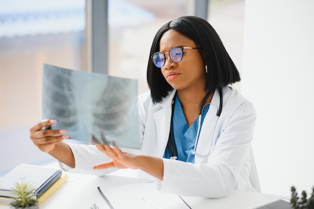 Jeune médecin professionnel afro-américain examinant la radiographie de la poitrine des patients