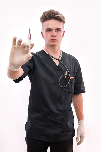 Jeune médecin avec seringue isolé sur blanc. Notion de vaccination