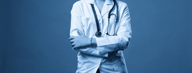 Jeune médecin avec stéthoscope sur fond bleu foncé tourné en studio avec espace de copie