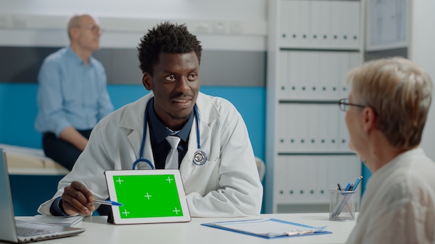 Jeune médecin avec technologie d'écran vert sur tablette