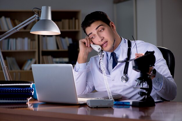 Jeune médecin travaillant tard au bureau