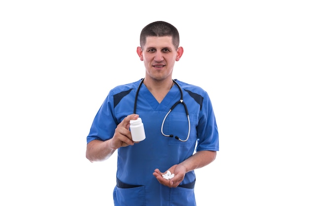 Jeune médecin en uniforme bleu prend des pilules de pots isolés sur fond blanc