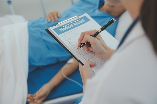 Jeune médecin utilise un stéthoscope pour écouter le rythme cardiaque du patient Photo d'une femme médecin donnant un contrôle à un patient de sexe masculin