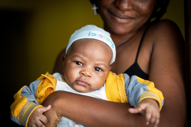 Jeune mère afro-américaine tenant son bébé à l'intérieur