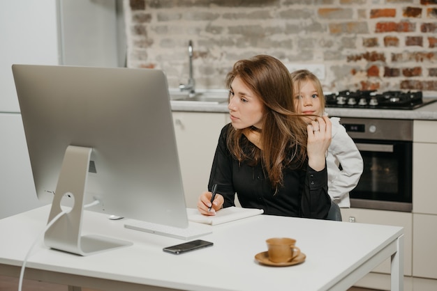 Jeune mère aidant sa fille à faire ses devoirs