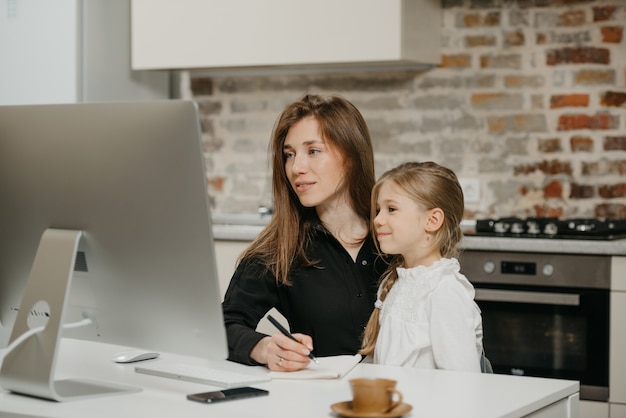 Jeune mère aidant sa fille à faire ses devoirs