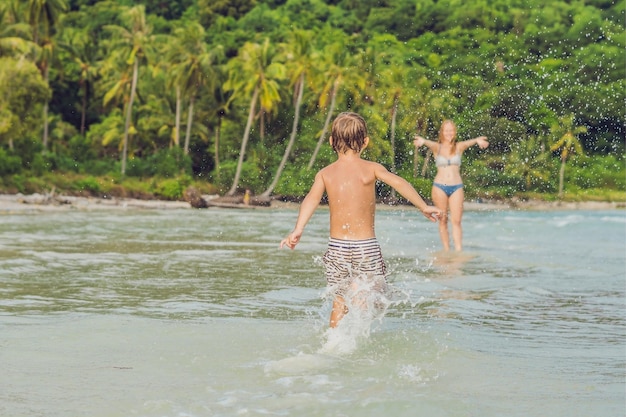 Jeune mère aimante et son petit fils jouant sur la plage