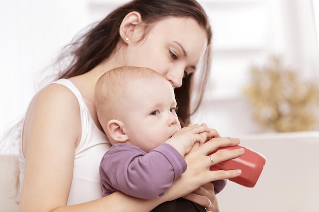 Une jeune mère attentionnée nourrit le bébé. le concept de maternité