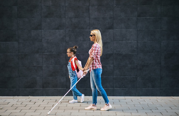 Photo jeune mère aveugle marchant avec sa petite fille dans la rue de la ville. ils portent des masques de protection du visage. retour à l'école et nouveau concept de mode de vie du coronavirus.