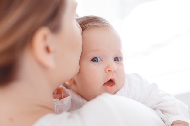 Jeune mère et bébé nouveau-né dans une chambre blanche