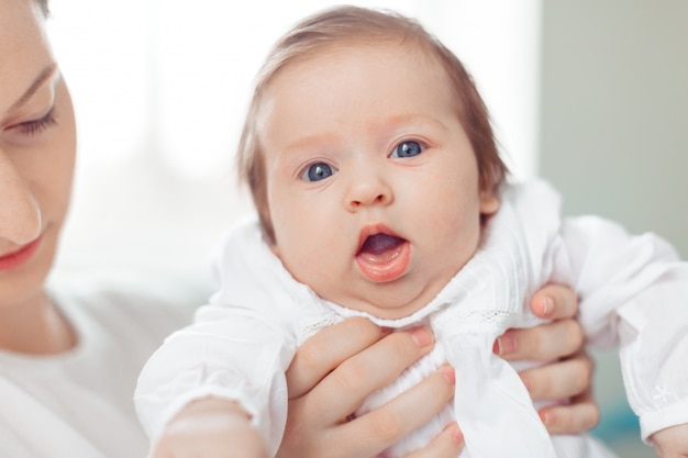 Jeune mère et bébé nouveau-né dans une chambre blanche