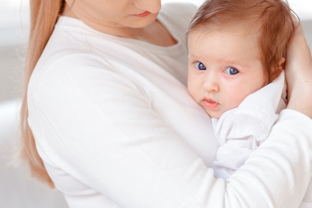 Jeune Mère Et Bébé Nouveau-né Dans Une Chambre Blanche