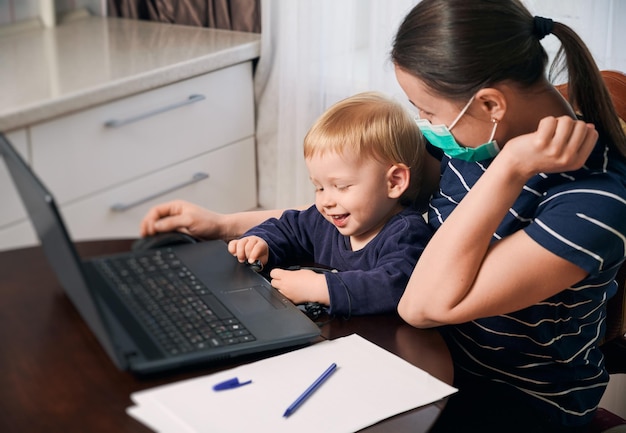 Jeune mère en congé de maternité essayant de travailler en freelance près du bureau avec un enfant en bas âge