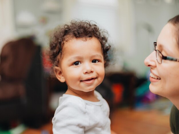 Photo jeune mère du millénaire et jeune garçon diversifié à la maison se liant ensemble