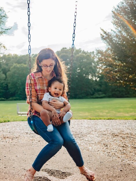 Photo une jeune mère du millénaire et un tout-petit garçon diversifié se lient à l'extérieur dans un parc local