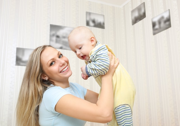 Jeune mère embrassant bébé à la maison