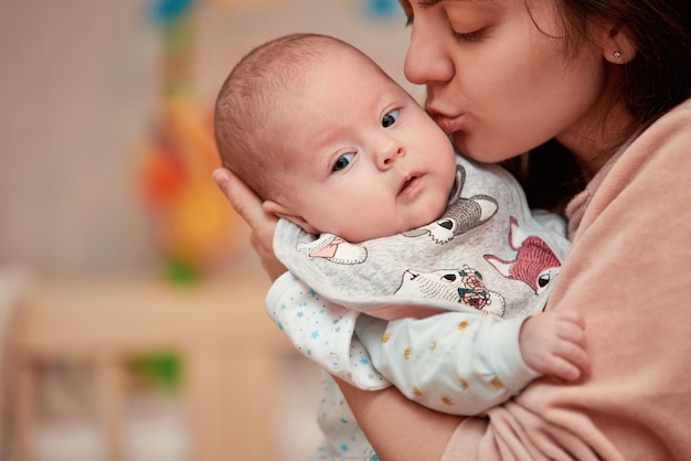 Photo jeune mère embrassant son bébé nouveau-né