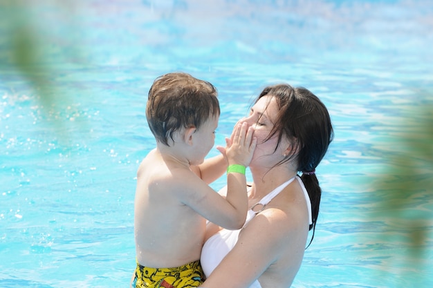 Jeune mère et enfant dans la piscine bleue