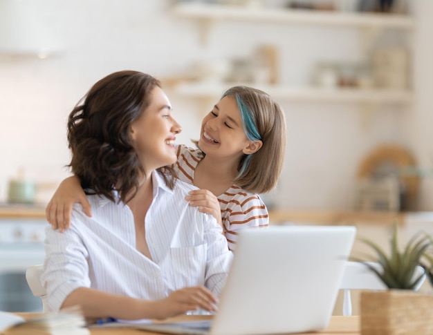 Jeune mère avec enfant travaillant sur l'ordinateur Famille à la maison Travail à distance