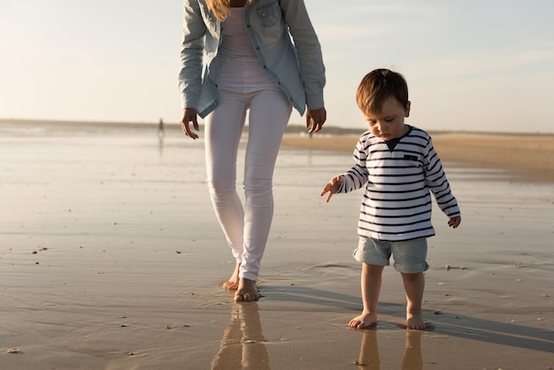 Jeune mère explorant la plage avec un tout-petit