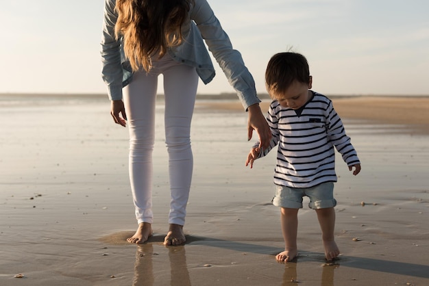 Jeune mère explorant la plage avec un tout-petit