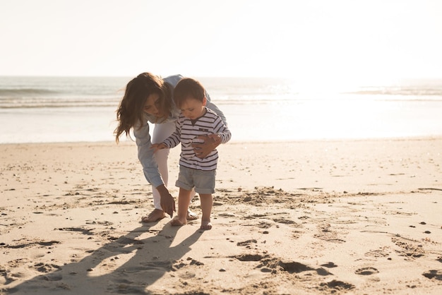 Jeune mère explorant la plage avec un tout-petit