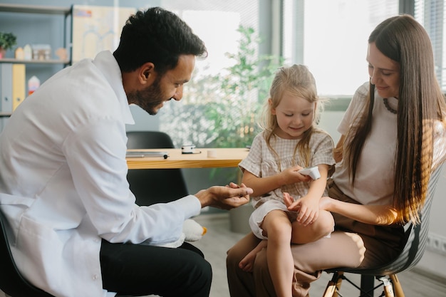 Photo une jeune mère avec une fille d'âge préscolaire dans le cabinet du médecin