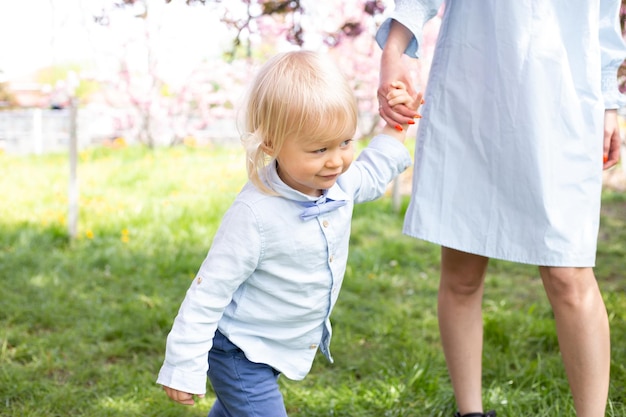 Jeune mère jouant avec un petit fils dans le parc au printemps