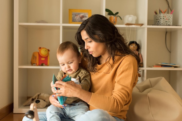 Jeune mère jouant avec un tout-petit à la maison