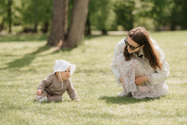 Une jeune mère joue avec sa fille de 7 mois dans le pré