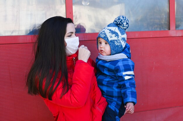 Jeune mère malade portant un masque chirurgical avec son bébé pendant le coronavirus, épidémie de pandémie de Covid-19.