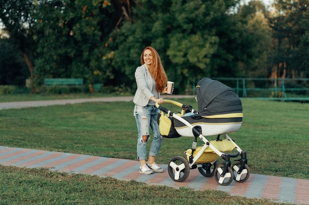 Jeune mère marchant avec son enfant le matin tout en buvant