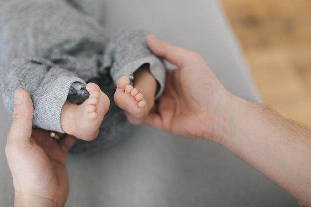 jeune mère ou médecin mains tenant les petits pieds pieds nus du nouveau-né. Bon moment de parentalité. Fermer.