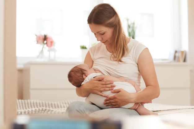 Jeune mère nourrissant bébé