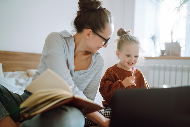 Jeune mère parlant au téléphone et discutant de problèmes de travail tout en s'occupant de son enfant Covid19