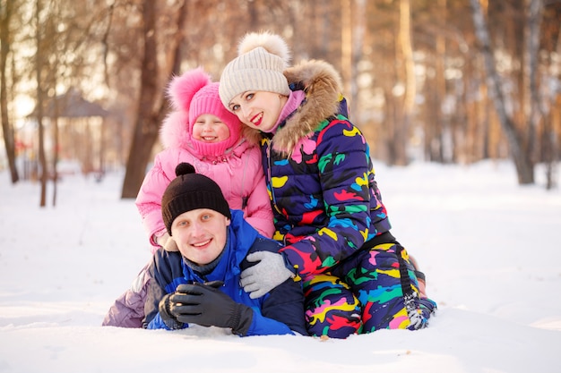 Jeune mère et père avec un enfant assis sur lui