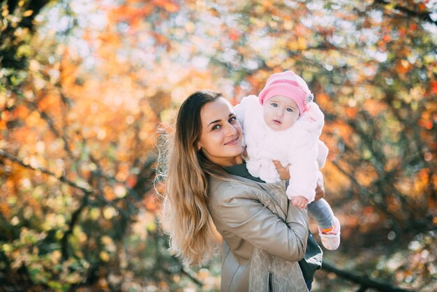 Jeune mère avec petite fille dans la forêt d'automne