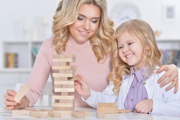 Jeune mère et petite fille jouant avec des blocs de bois