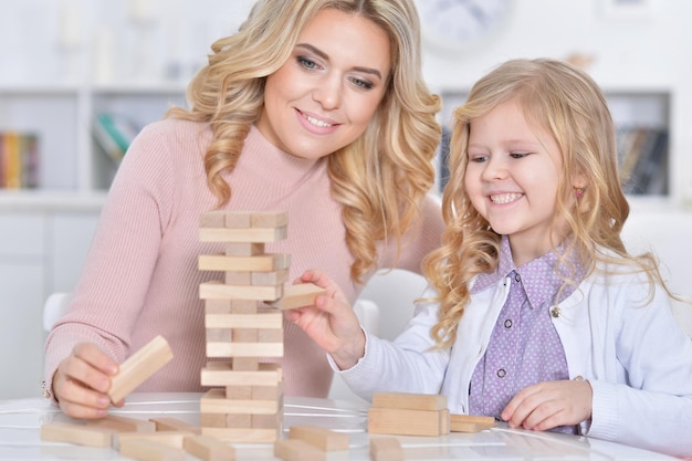 Jeune mère et petite fille jouant avec des blocs de bois