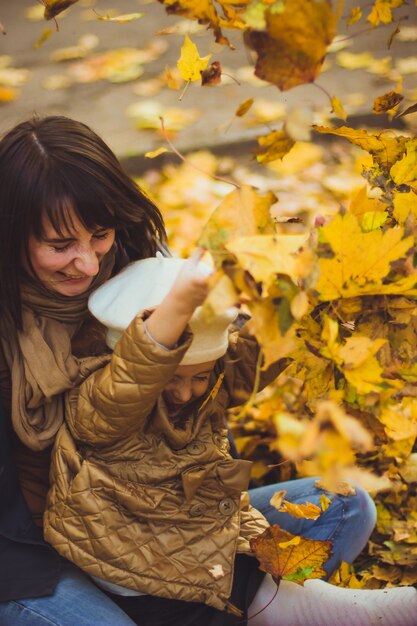 La jeune mère et sa fille s'amusent à l'automne