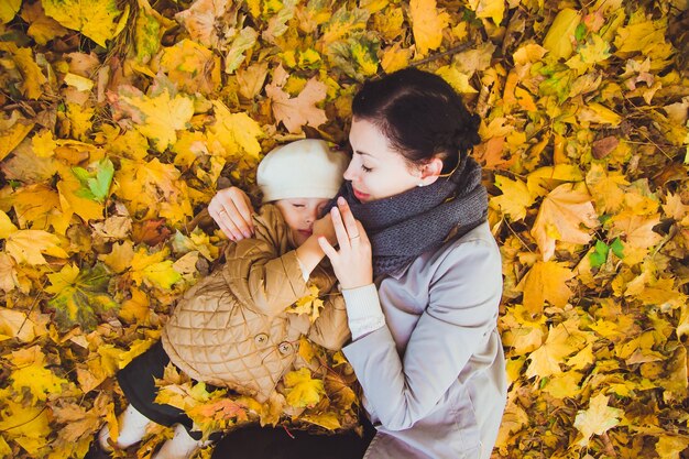 La jeune mère et sa fille s'amusent à l'automne