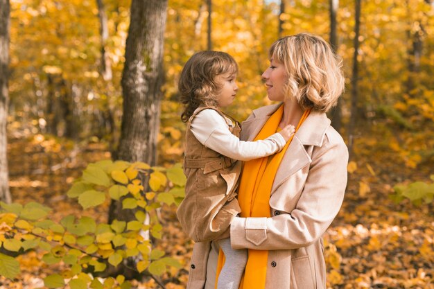 Jeune mère avec sa petite fille dans un parc d'automne concept de parentalité et d'enfants de la saison d'automne