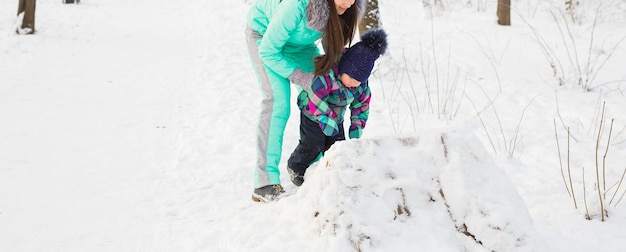 Jeune mère et sa petite fille profitant d'une belle journée d'hiver à l'extérieur.