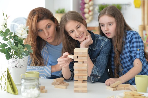 Jeune mère et ses filles jouant avec des blocs de bois