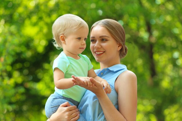 Jeune mère avec son enfant mignon dans un parc verdoyant