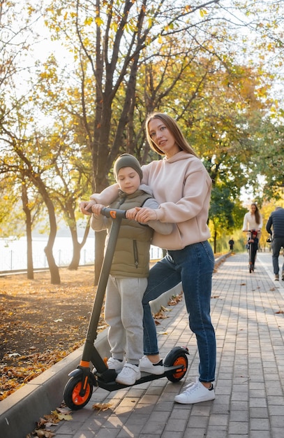 Une jeune mère et son fils se promènent dans le parc en segway.