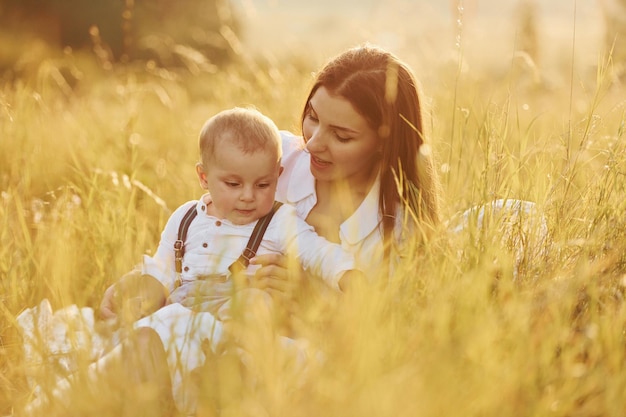 Jeune mère avec son petit fils est à l'extérieur dans le domaine agricole Beau soleil