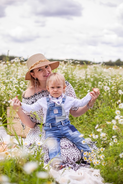 Jeune mère et son petit fils mignon marchant dans un champ