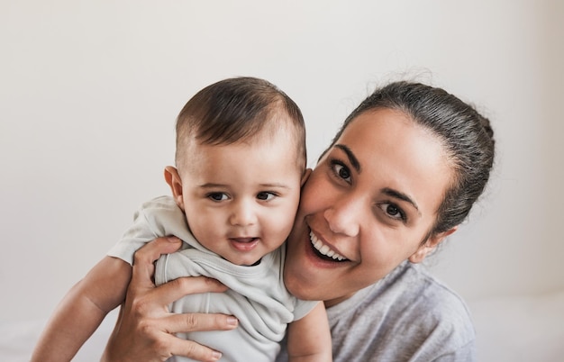 Jeune mère tenant un tout-petit et souriant à la caméra Concept d'amour de la mère et de l'enfant de la famille