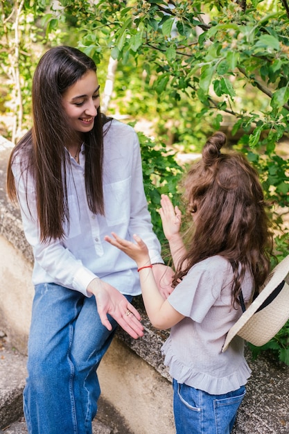 Une jeune mère tient la main de sa petite fille et parle.